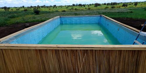 a large pool of water in a wooden fence at Amboseli Amanya Lodge in Rift Valley