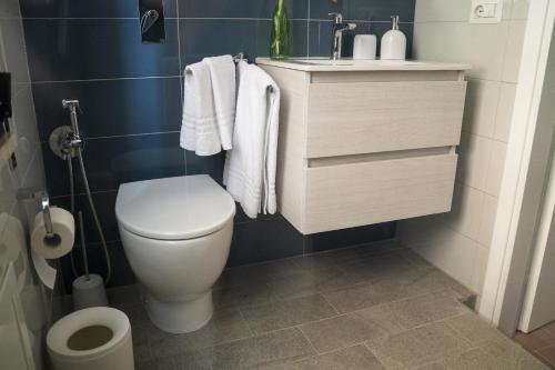 a bathroom with a toilet and a sink with towels at Regina Apartments in Mazara del Vallo