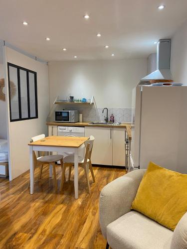 un salon avec une table et une cuisine dans l'établissement Studio Cosy, à Pélissanne