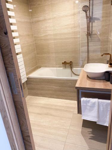 a bathroom with a tub and a sink and a shower at Studio Palace 404 in Špindlerův Mlýn