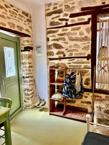 a room with a stone wall and a green door at Atelies Stone House in Potamia
