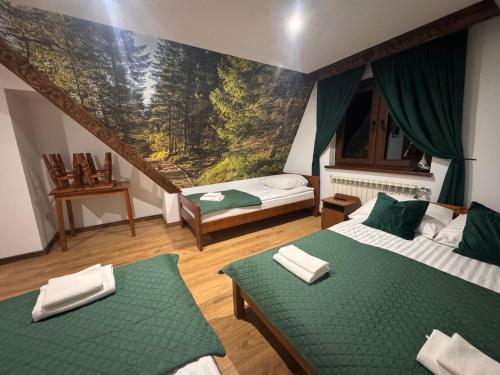 a room with two beds and a painting on the wall at Pensjonat U Zosi in Male Ciche