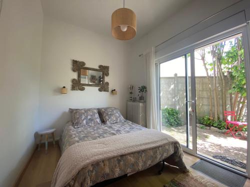 a bedroom with a bed and a large window at Les Charmettes chambre d hôtes indépendante in Villemoisson-sur-Orge
