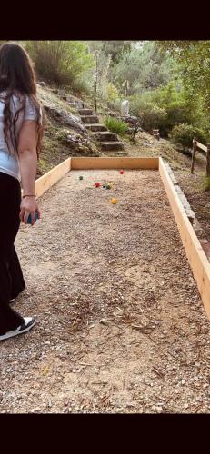 a woman standing on a dirt ground with a group of balls at B&B IL VECCHIO GELSO in Palinuro