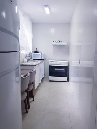 a white kitchen with a stove and a sink at Espaço IN 4 Quarto Brooklin in Sao Paulo