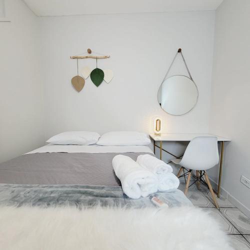 a bedroom with a bed and a desk and a mirror at Espaço IN 4 Quarto Brooklin in Sao Paulo