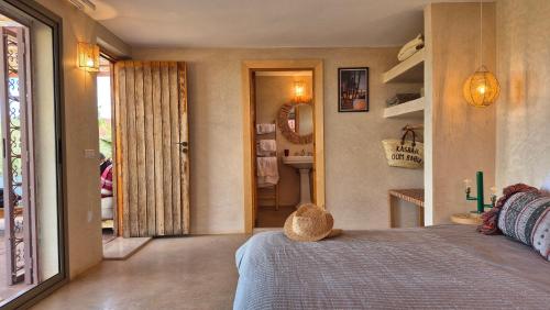 a bedroom with a bed and a door to a bathroom at Kasbah Oum Rabia in Boulaouane