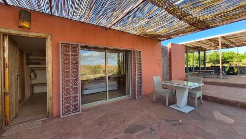 a patio with a table and a view of a bed at Kasbah Oum Rabia in Boulaouane