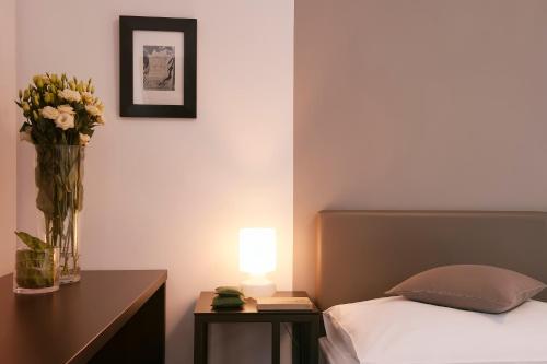 a bedroom with a bed and a table with a vase of flowers at Villa na Vinici in Prague