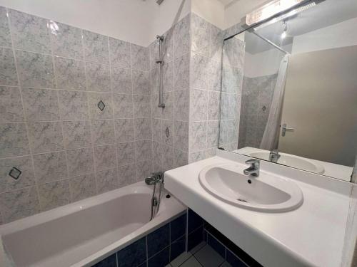 une salle de bain blanche avec un lavabo et une baignoire dans l'établissement 3 pièces à Quiberon - 48m², balcon, plage à 20m, parking, animaux acceptés - FR-1-478-65, à Quiberon