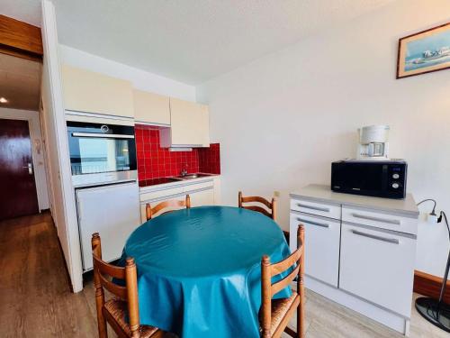 - une cuisine avec une table bleue dans une pièce dans l'établissement Studio cosy à Quiberon, 27m², proche mer, parking, animaux admis - FR-1-478-111, à Quiberon