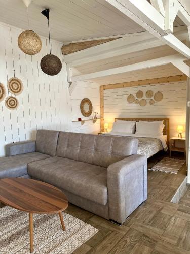 a living room with a couch and a bed at The Garden House in Kavála