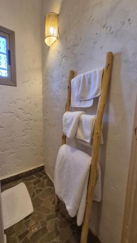 a towel rack in a bathroom with white towels at Kasbah Oum Rabia in Boulaouane