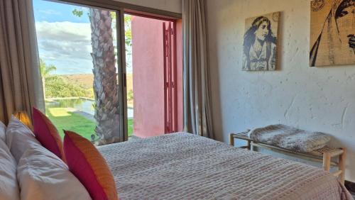 a bedroom with a bed and a large window at Kasbah Oum Rabia in Boulaouane