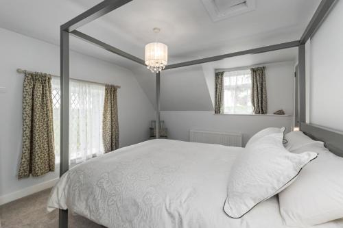 une chambre avec un grand lit blanc avec des oreillers blancs dans l'établissement Lavender Cottage, à Charlemont
