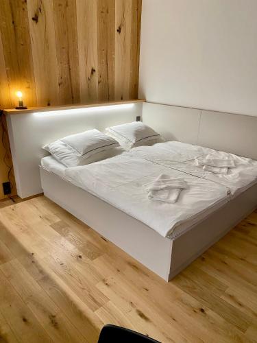 a white bed with white sheets and pillows on it at Studio Palace 404 in Špindlerův Mlýn