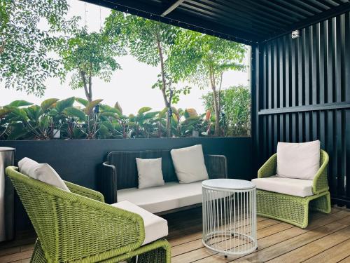 a patio with two chairs and a couch and a table at Iconic Regency Seaview Homestay with Rooftop Pool in Bayan Lepas