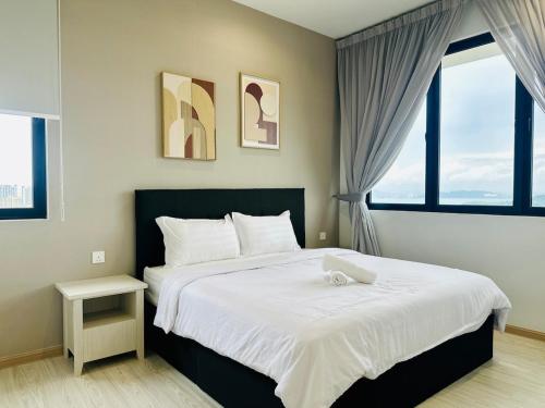 a bedroom with a large bed and two windows at Iconic Regency Seaview Homestay with Rooftop Pool in Bayan Lepas