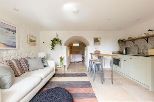 a living room with a couch and a kitchen at OWH Studio by The Butler Collection in Arundel