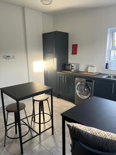 a kitchen with a table and two stools in it at An Sean Teach in Fodry