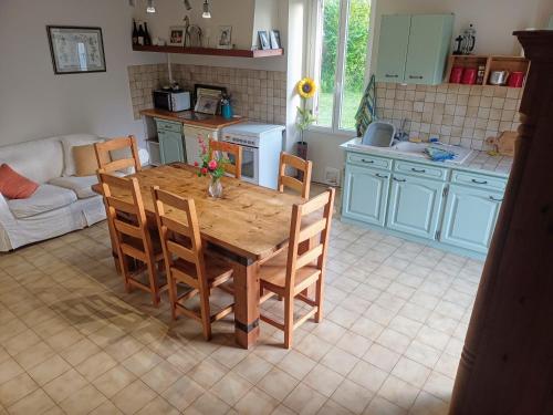 eine Küche mit einem Holztisch und Stühlen in einem Zimmer in der Unterkunft Large 4 bed house available for short stays in Petit-Bersac