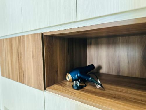 a blue blow dryer in a wooden cabinet at Iconic Regency Seaview Homestay with Rooftop Pool in Bayan Lepas