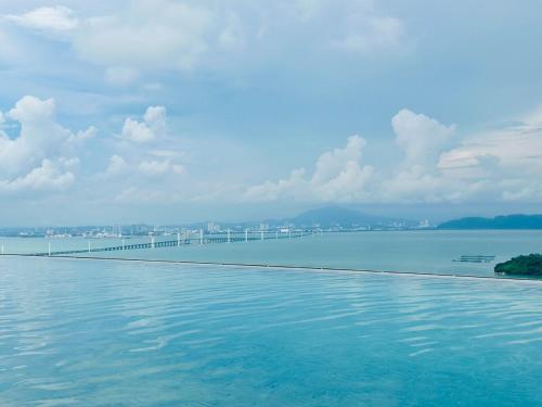 a swimming pool with a bridge in the water at Iconic Regency Seaview Homestay with Rooftop Pool in Bayan Lepas