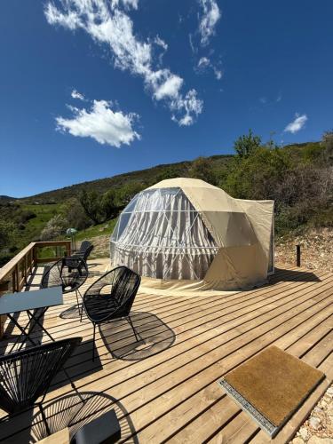 une tente installée au-dessus d'une terrasse en bois dans l'établissement Le dôme de Jèpo, à Ilonse
