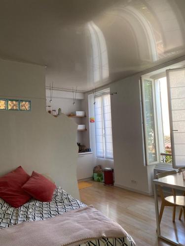 une chambre avec un lit, une table et des fenêtres dans l'établissement Lumineux studio 30 m2 Parc 26ème centenaire, à Marseille