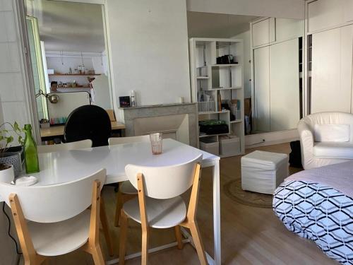 un salon avec une table et des chaises blanches dans l'établissement Lumineux studio 30 m2 Parc 26ème centenaire, à Marseille