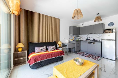 une petite chambre avec un lit et une cuisine dans l'établissement Modern studio - AC - 2P - Cannes, à Cannes