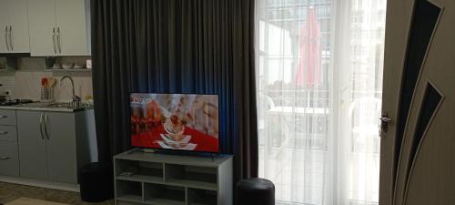 a kitchen with a tv on a stand next to a window at Guesthouse Next to beach in Batumi