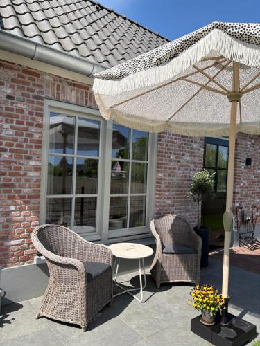 a patio with a table and chairs and an umbrella at B&B de Plattelandshoeve in Rhenen