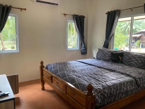 a bedroom with a bed and two windows at Grey Garden in Thong Sala