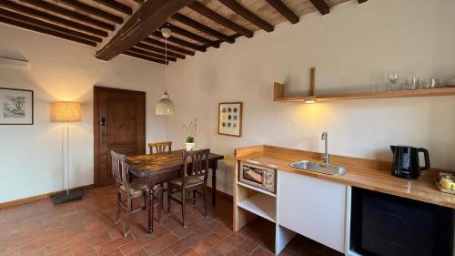 a kitchen with a wooden table and a counter top at Bio Agriturismo Il Vigno in Caprese Michelangelo