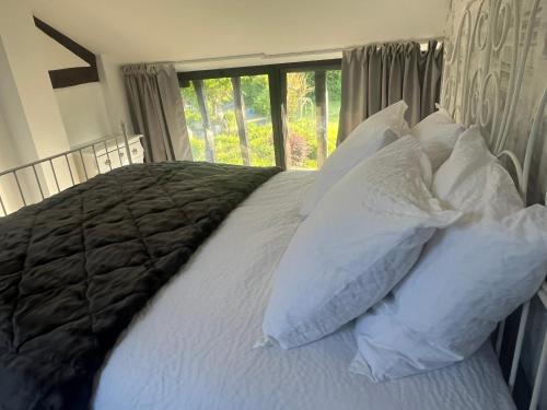 une chambre avec un lit avec des oreillers et une fenêtre dans l'établissement Gite 3, Domaine Logis Gascogne, à Saint-Justin