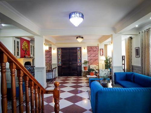 a living room with a blue couch and a staircase at The Sherpas Rest in Darjeeling