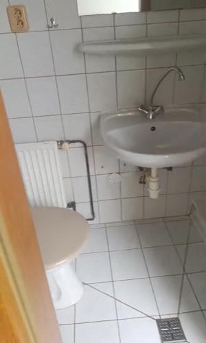 a white bathroom with a sink and a toilet at Penzion Hořice in Hořice
