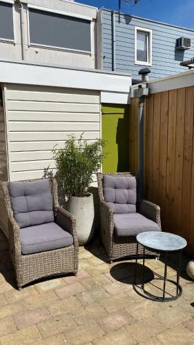 two wicker chairs and a table on a patio at Spes Salutis in Badhoevedorp