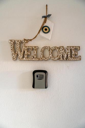 a sign with the word welcome hanging on a wall at Stefanias apartment in Neos Marmaras