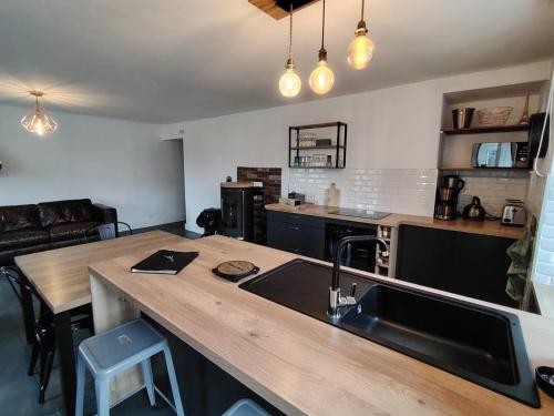 une cuisine avec un évier et un plan de travail en bois dans l'établissement Les Frangins du Mont Saint Michel, à Pontorson