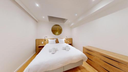 une chambre avec un lit blanc et un miroir dans l'établissement Le Pignon 2 chambres 2 salle de bain, à Strasbourg