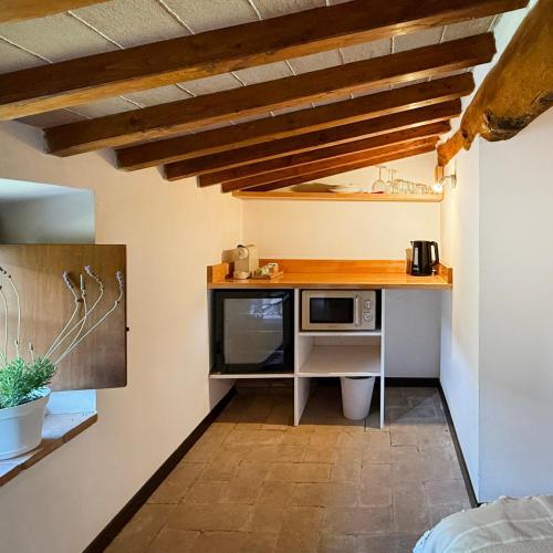 a small kitchen with a desk and a microwave at Bio Agriturismo Il Vigno in Caprese Michelangelo