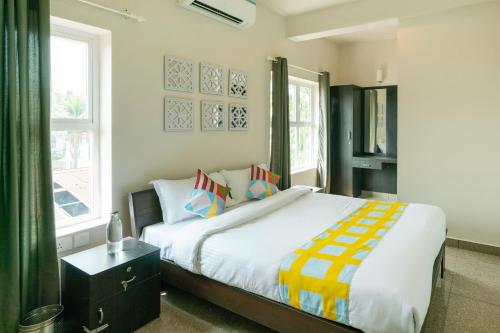 a bedroom with a large bed with colorful pillows at Super Hotel O Elegant KINGS PARK RESIDENCY in Cochin