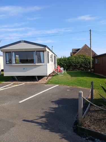 a white caravan parked in a parking lot at L91 Rebecca's place in Mablethorpe