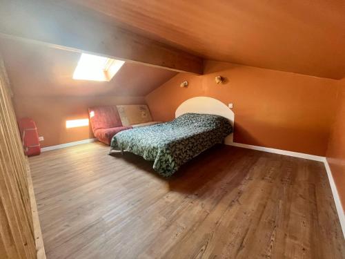 a small attic room with a bed and a couch at Appartement cosy in Naujac-sur-Mer