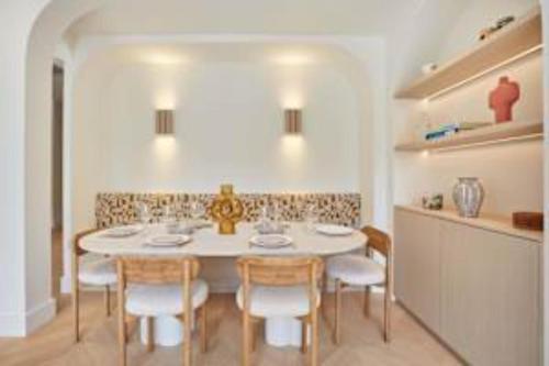 une salle à manger avec une table et des chaises blanches dans l'établissement Sumptuous apartment with garden Arc de Triomphe, à Paris