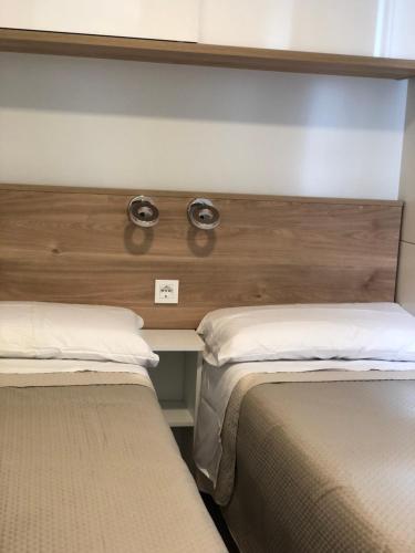 two beds sitting next to each other in a room at Tiny house on the beach in Lido di Classe