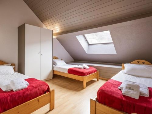 une chambre mansardée avec deux lits et une lucarne dans l'établissement Duplex 6 pièces pour 12 pers. avec terrasse sud, spa, sauna et garage - Valloire, Les Verneys - FR-1-263-359, à Valloire