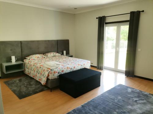 a bedroom with a bed and a large window at Casa das Marinhas in Caminha